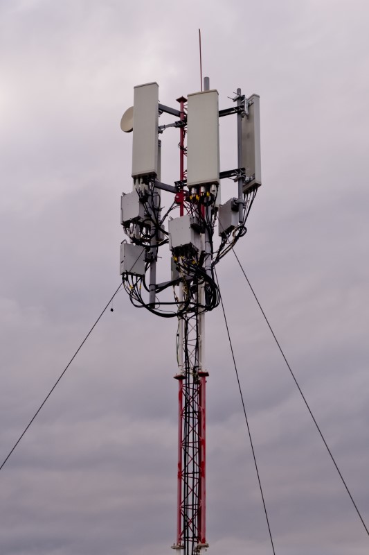 5G Cellular Tower with Cloudy Sky Background.